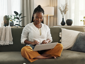 Woman in white shirt using her laptop on the couch Woman in white shirt using her laptop on the couch