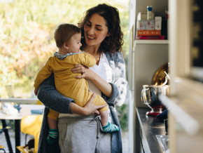 Mother holding baby in arms in a kitchen Mother holding baby in arms in a kitchen