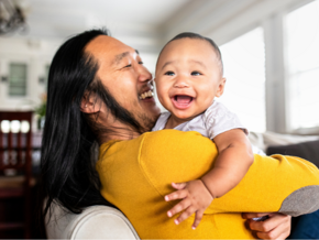 Asian dad holding young laughing baby Asian dad holding young laughing baby