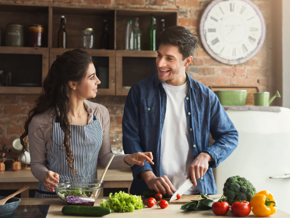 woman and man in the kitchen cutting up healthy food woman and man in the kitchen cutting up healthy food