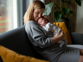 Mother holding her baby on the lounge cuddling Mother holding her baby on the lounge cuddling