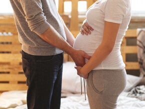Pregnant woman and her partner holding her belly Pregnant woman and her partner holding her belly