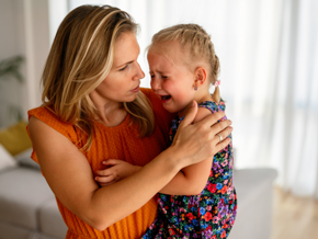 Woman holding her crying daughter