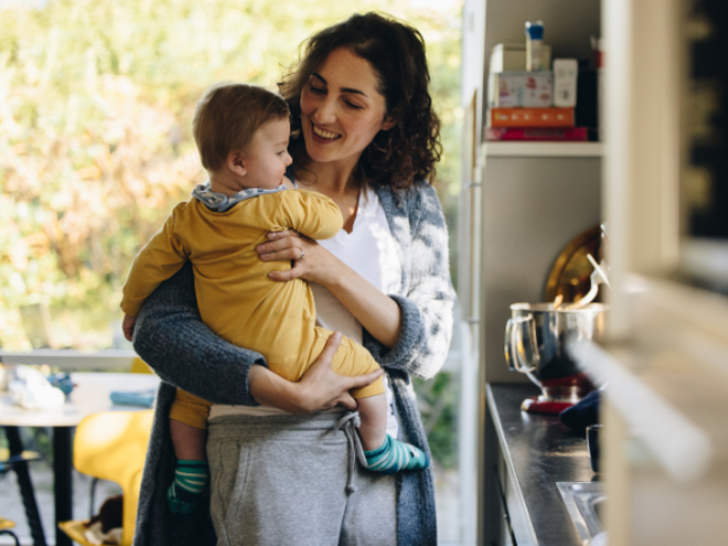 Mother holding baby in arms in a kitchen