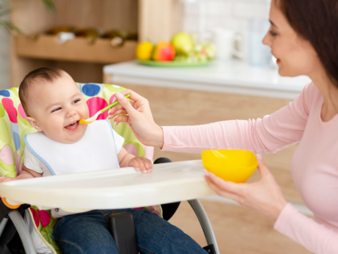 mother feeding baby with spoon