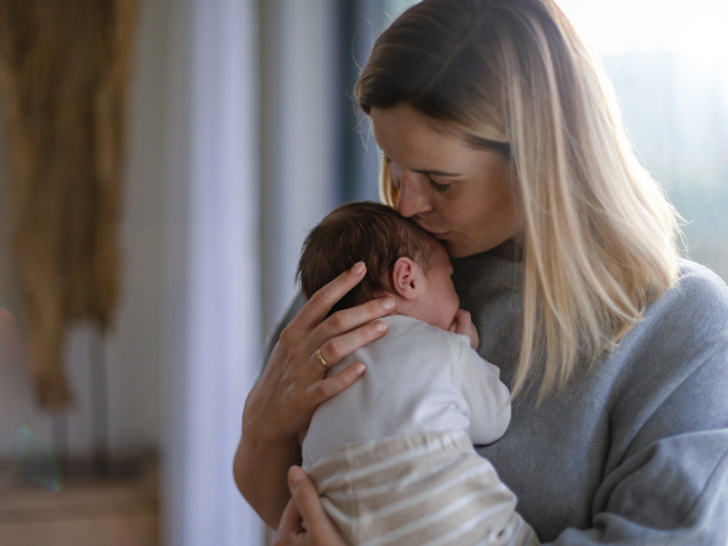 Mother kissing babies head Mother kissing babies head