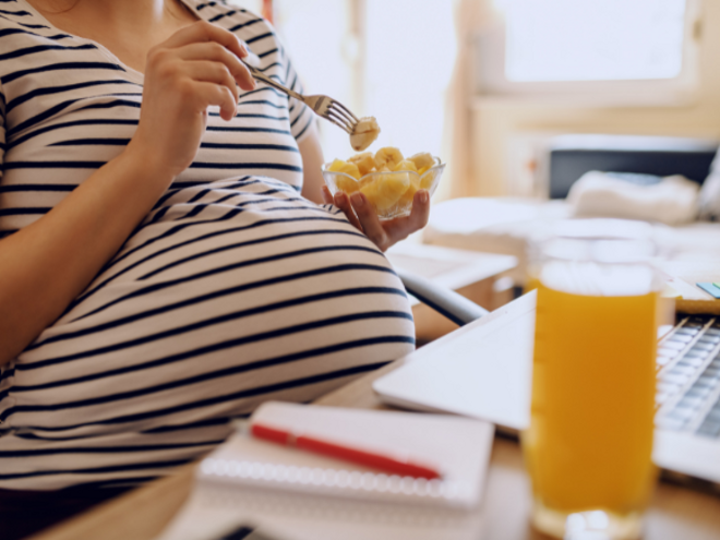 Pregnant woman eating banana