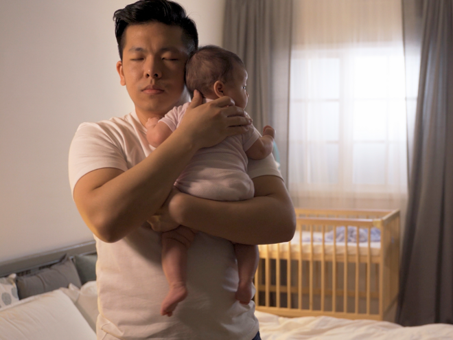 When Do Infants Sleep Through the Night dad making baby sleep