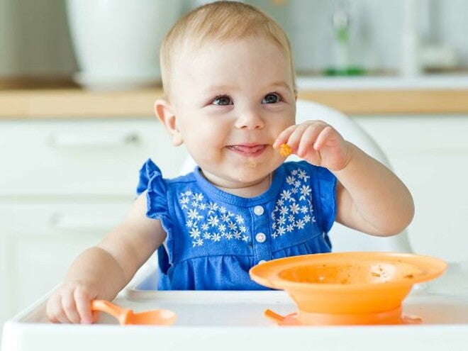 9 month old girl eating with spoon and bowl 9 month old girl eating with spoon and bowl